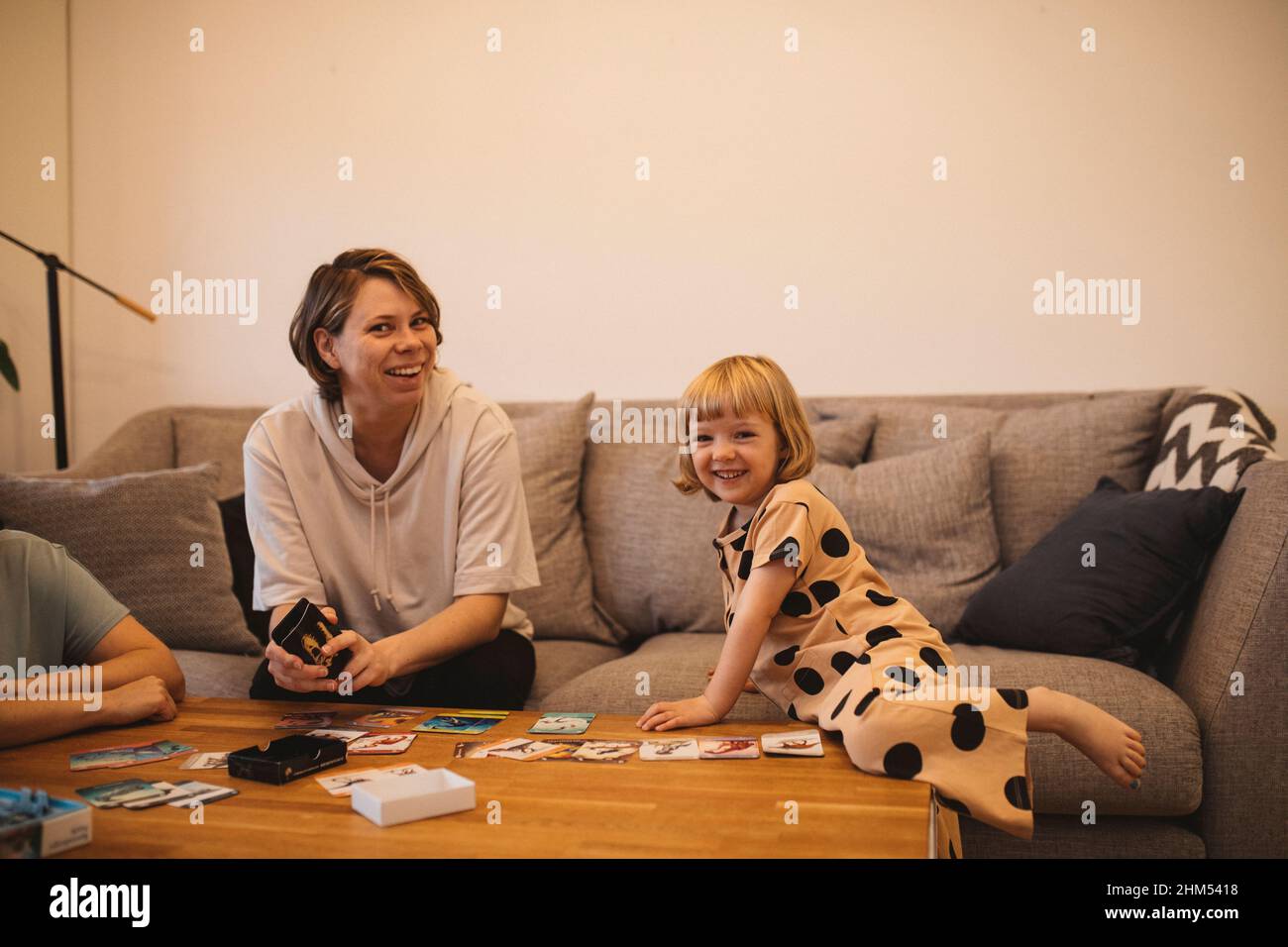 Smiling mother and daughters on sofa Stock Photo