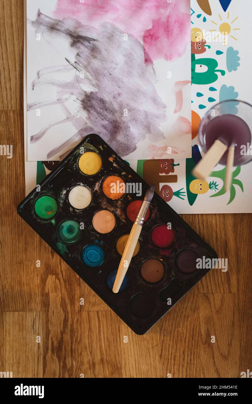 Abstract painting, paint box, and brushes on table Stock Photo