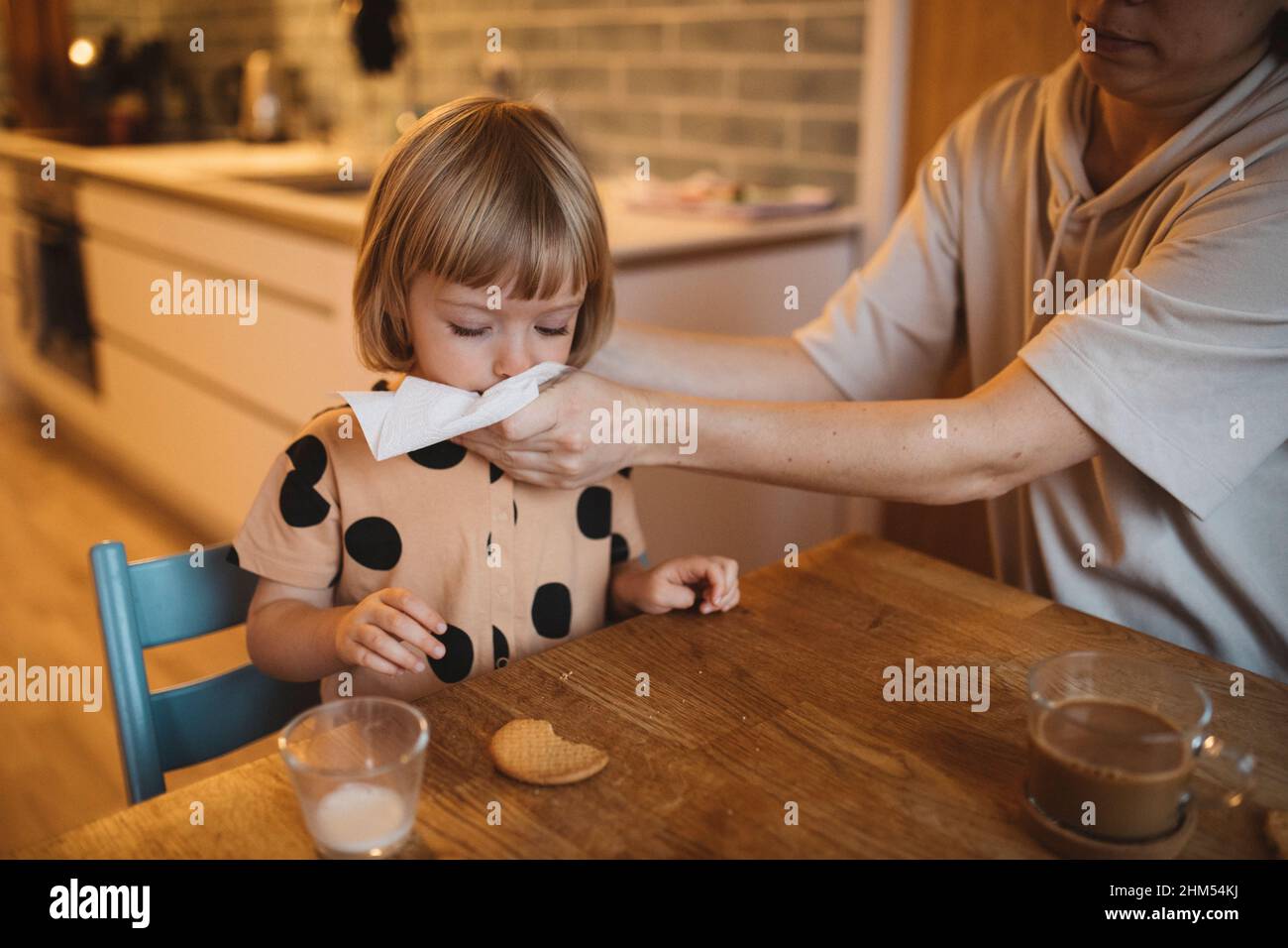 Mother cleaning daughter's mouth with tissue Stock Photo Alamy