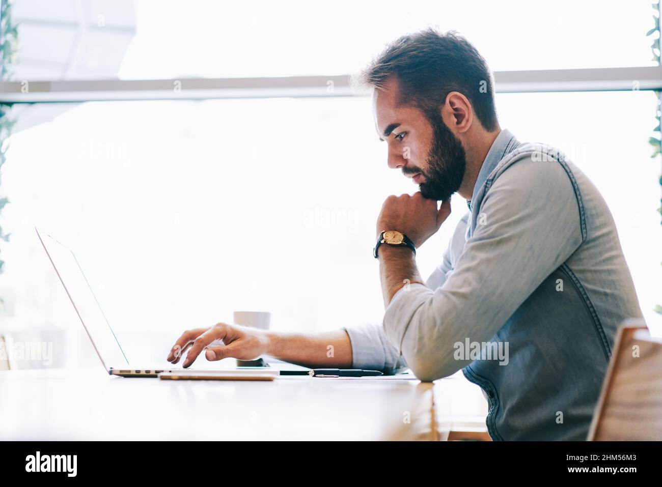 Focused male freelancer using laptop while working Stock Photo