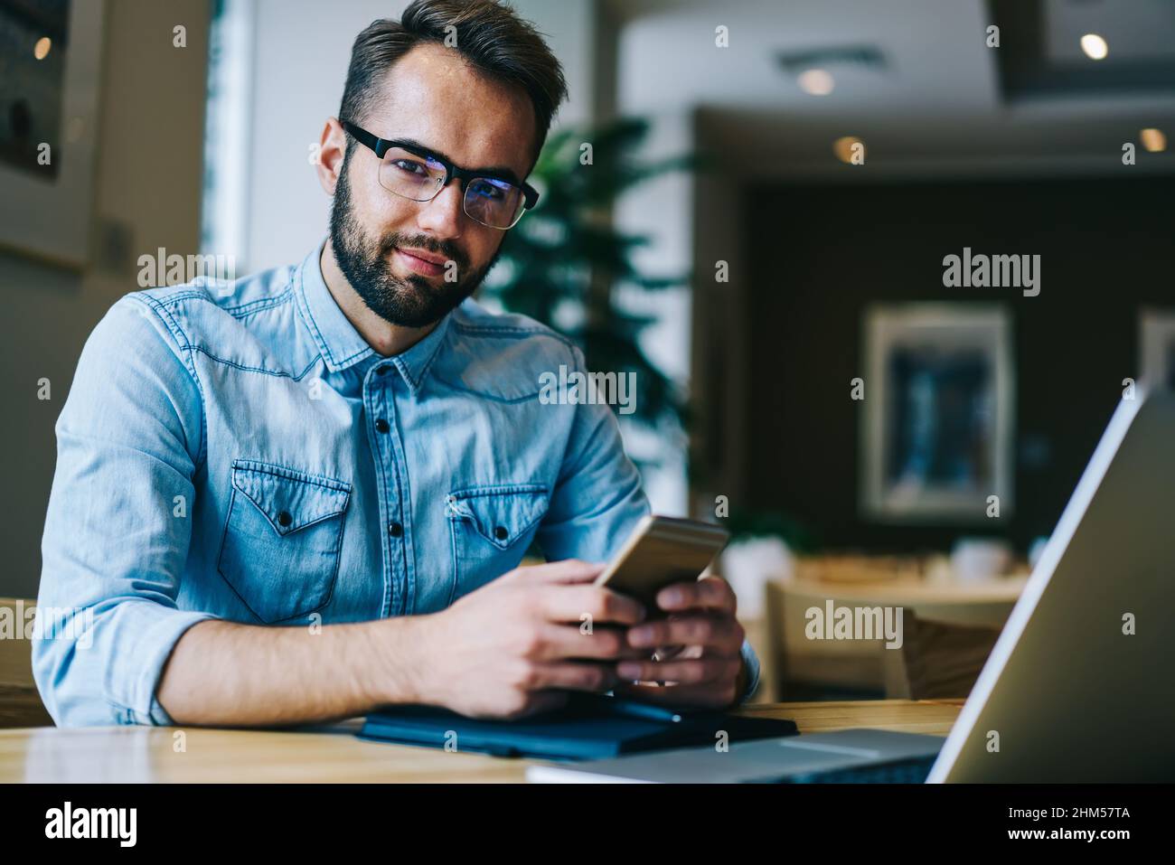 Positive man using smartphone in cafe Stock Photo