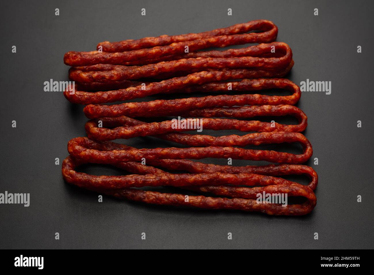 Cabanossi, dry sausage isolated on a black background Stock Photo - Alamy
