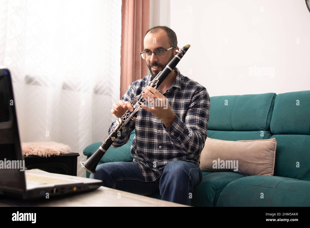 Clarinetist giving online clarinet class with the laptop from ho Stock Photo