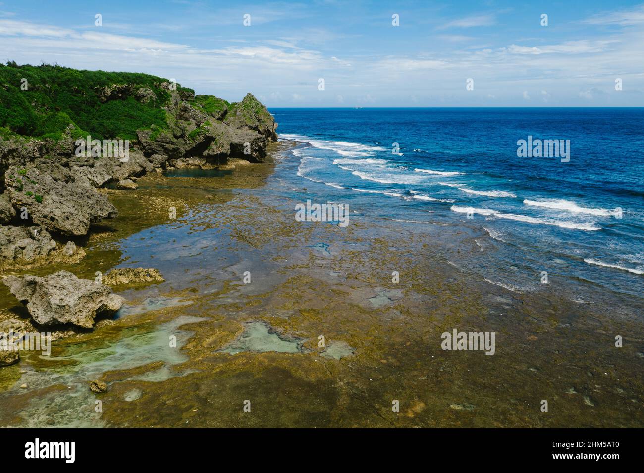 Tide pools, waves and blue ocean cliffs on coastline of island Stock Photo