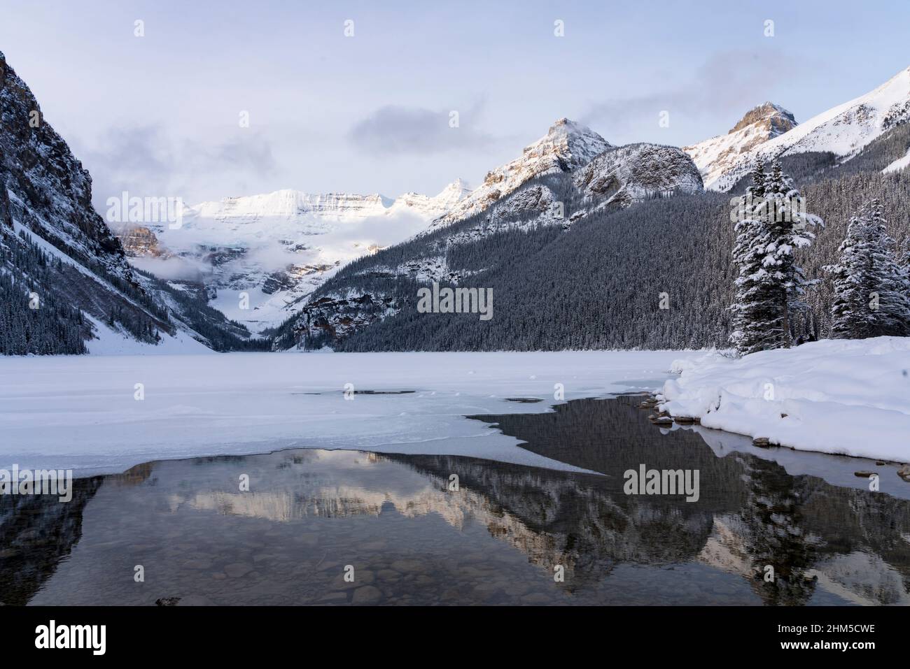 A view of a partially frozen Lake Louise in winter, Banff National Park ...