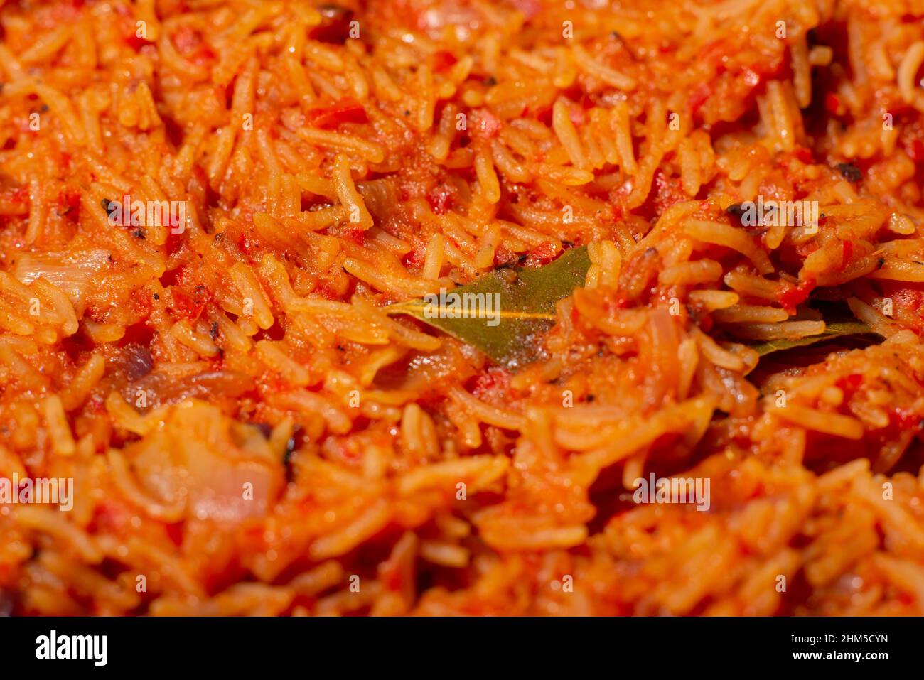 Jollof rice closeup. Background of rice cooked in tomato paste with
