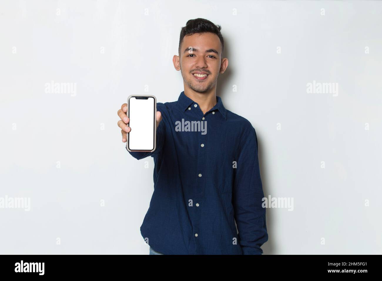 young man demonstrating mobile cell phone on white background Stock Photo