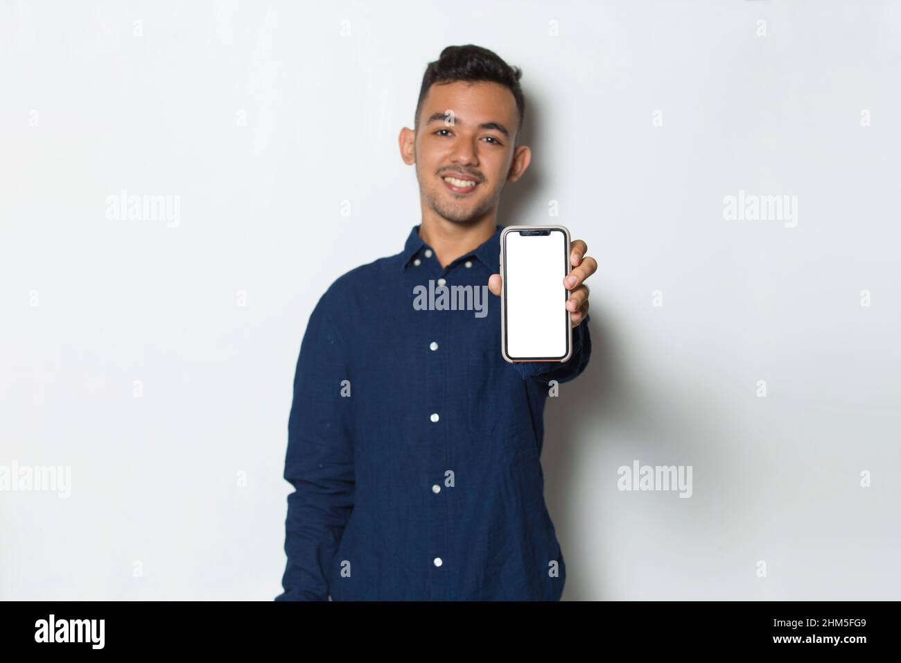 young man demonstrating mobile cell phone on white background Stock Photo