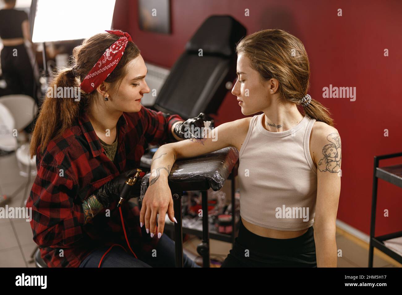 Focused tattoo artist removing excess ink from hand Stock Photo Alamy