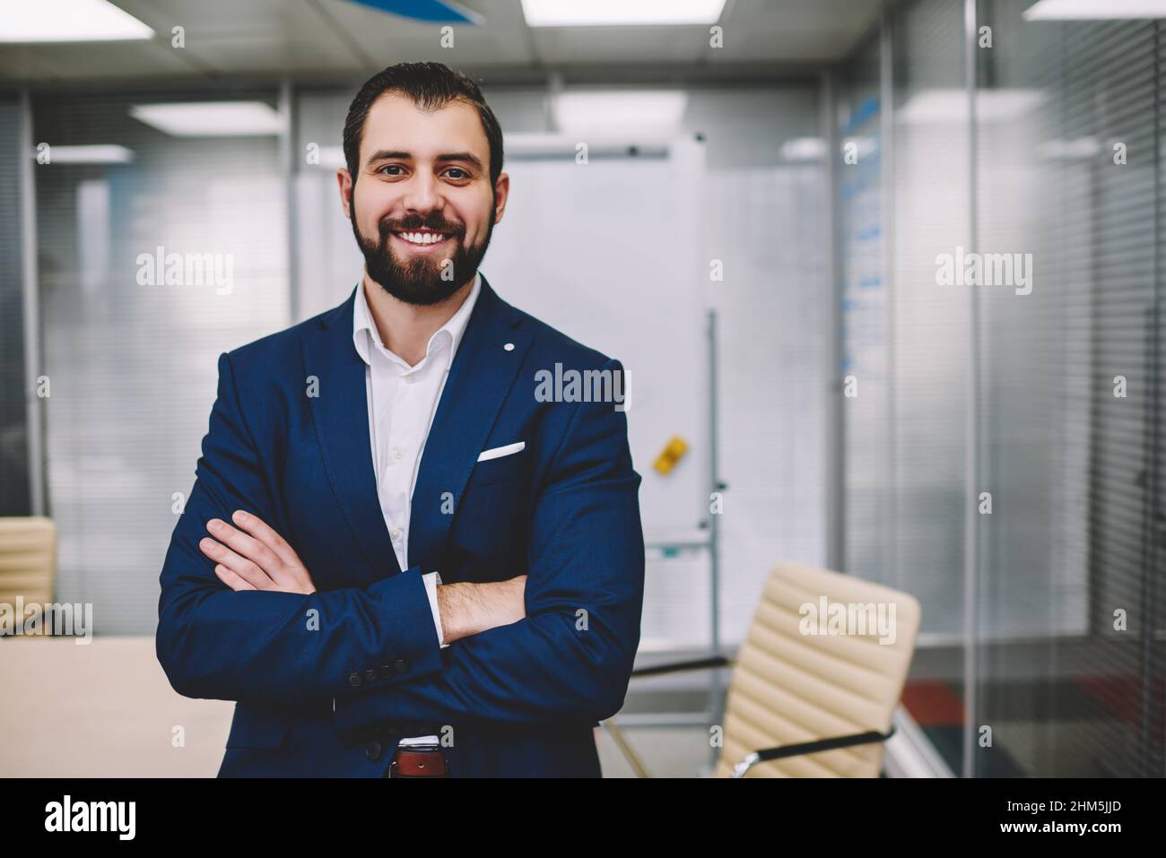 Happy businessman smiling and looking at camera in modern office Stock Photo