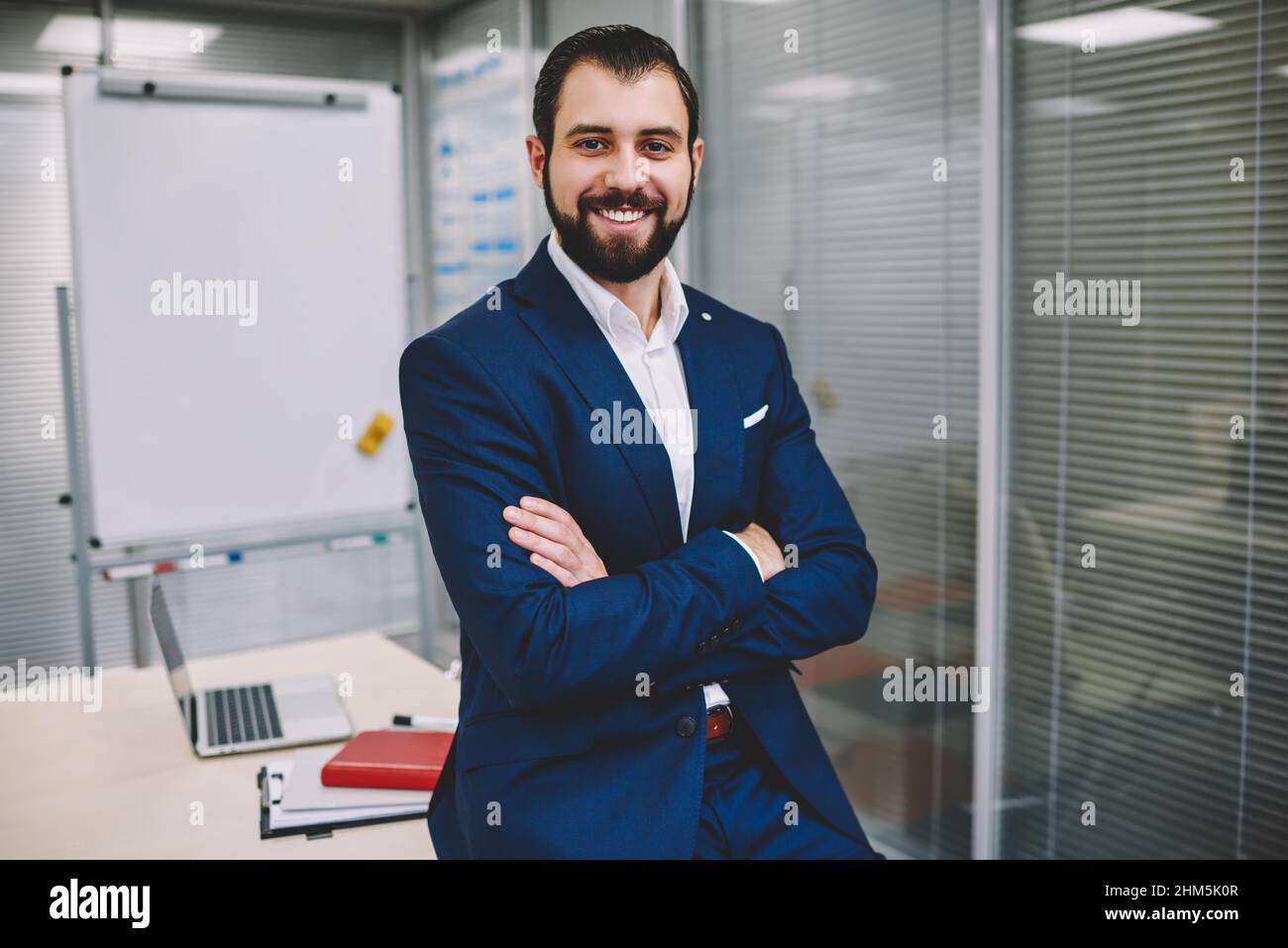 Cheerful businessman in confident pose looking at camera in modern office Stock Photo
