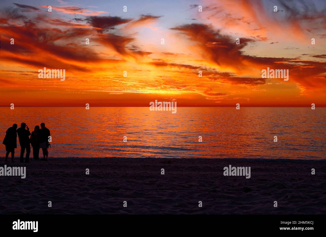 sunset; Gulf of Mexico; sand beach; 4 people silhouettes; brilliant sky; clouds; inspirational; nature, scene, Florida; Nokomis; FL; winter; horizont Stock Photo
