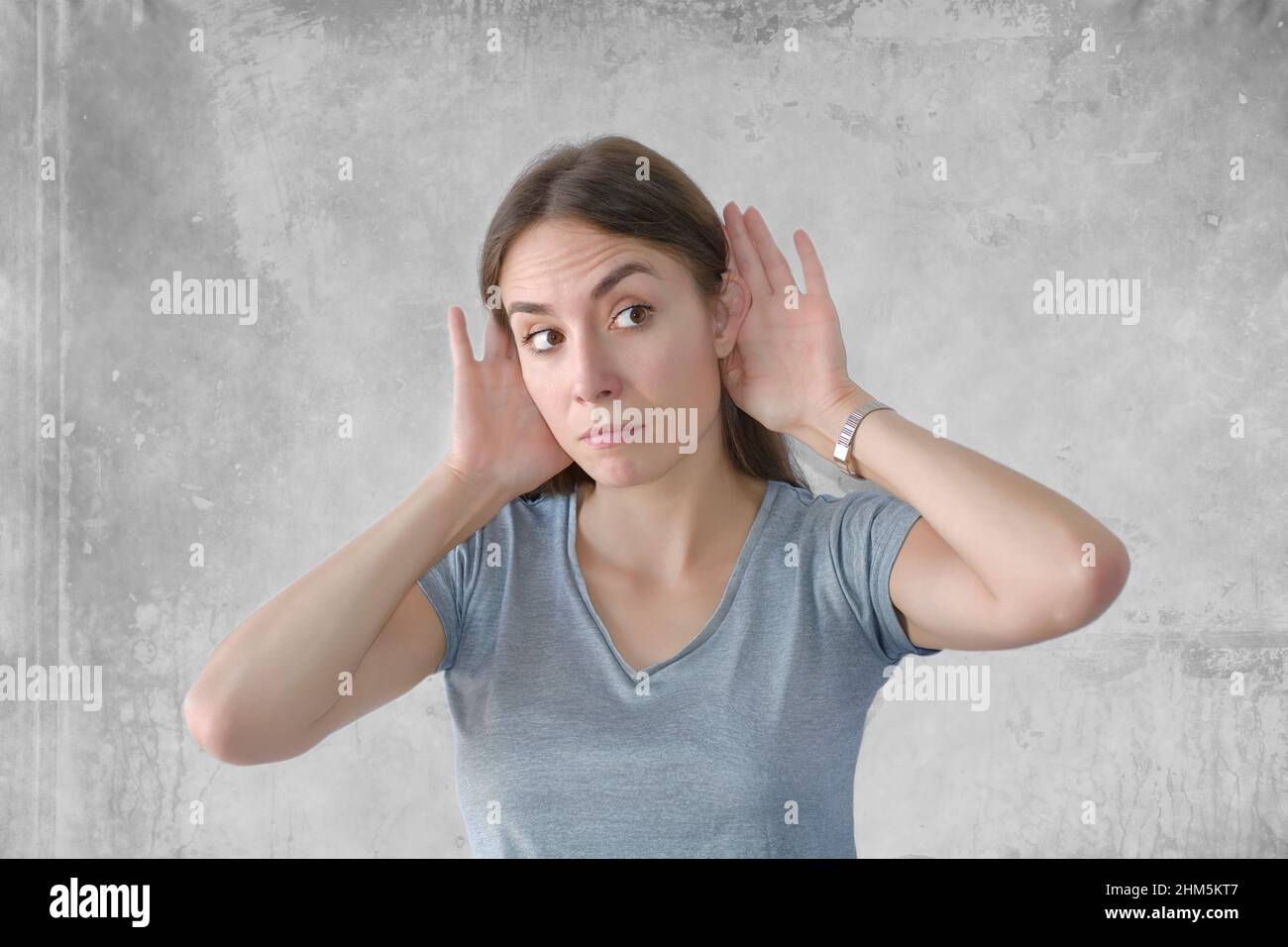 Young beautiful woman over background with hand over ears listening Stock Photo