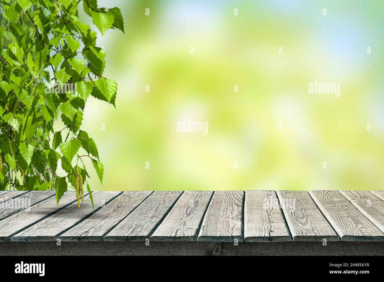 Empty wooden old table top for product display on blurred garden and summer season background. Stock Photo