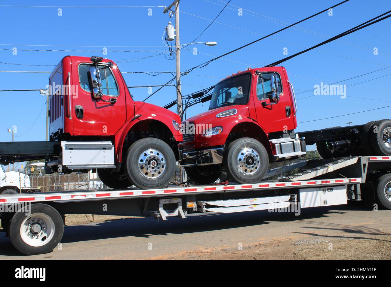 Two red truck cabs on flatbed for delivery Stock Photo