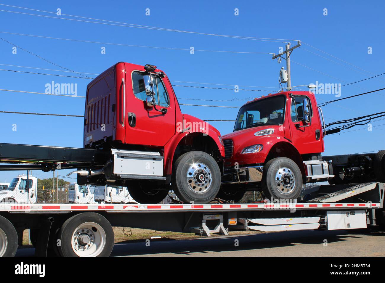 Two red trucks on flat bed truck Stock Photo
