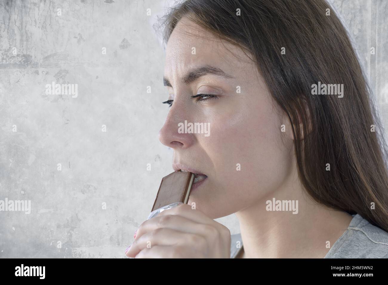 Close up of a woman eating a candy bar and enjoying Stock Photo Alamy