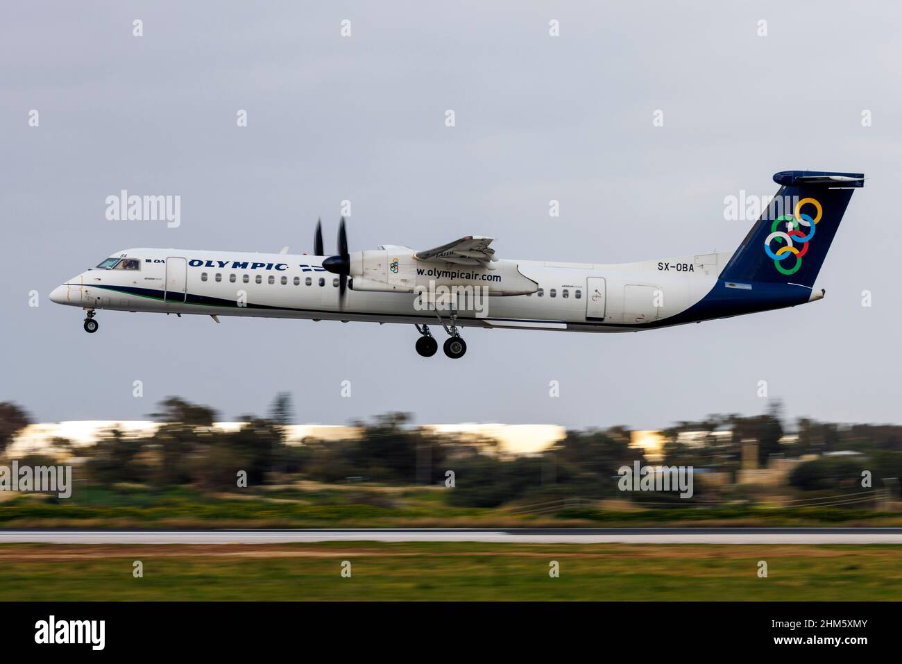 Olympic Bombardier DHC-8-402 Q400 (REG: SX-OBA) landing on a cloudy afternoon. Stock Photo