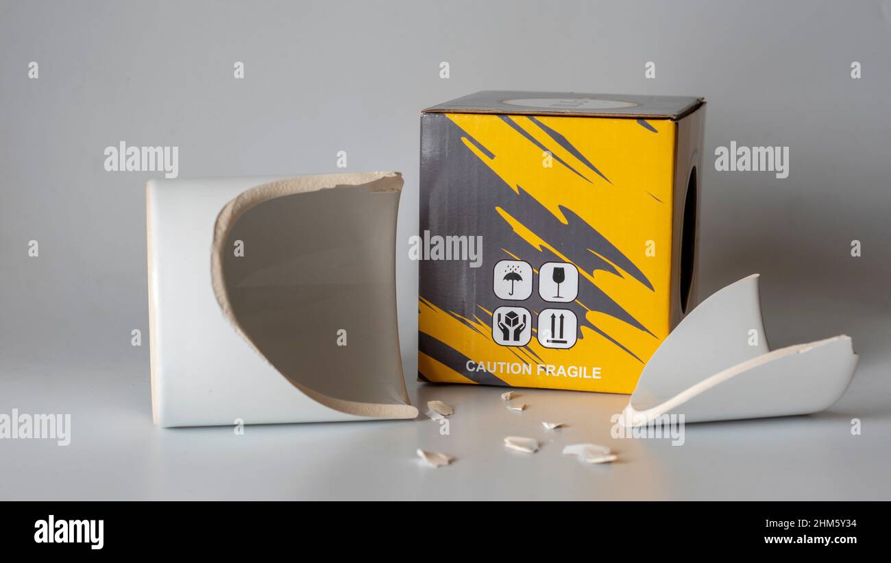 broken mug cup. Fragile cargo shipment. Mug glass broken during cargo transportation. storage box. image of what happens if there is no careful cargo Stock Photo