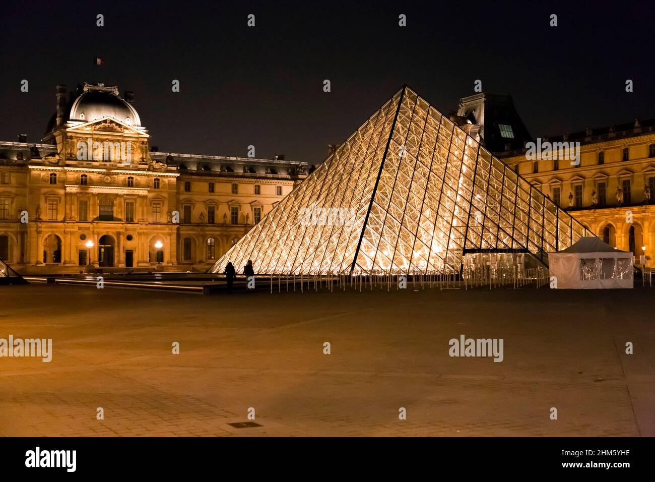 Paris, France - JAN 24, 2022: The glass pyramid of Louvre Museum, the main entrance to famous museum and gallery, completed in 1989. A beautiful winte Stock Photo