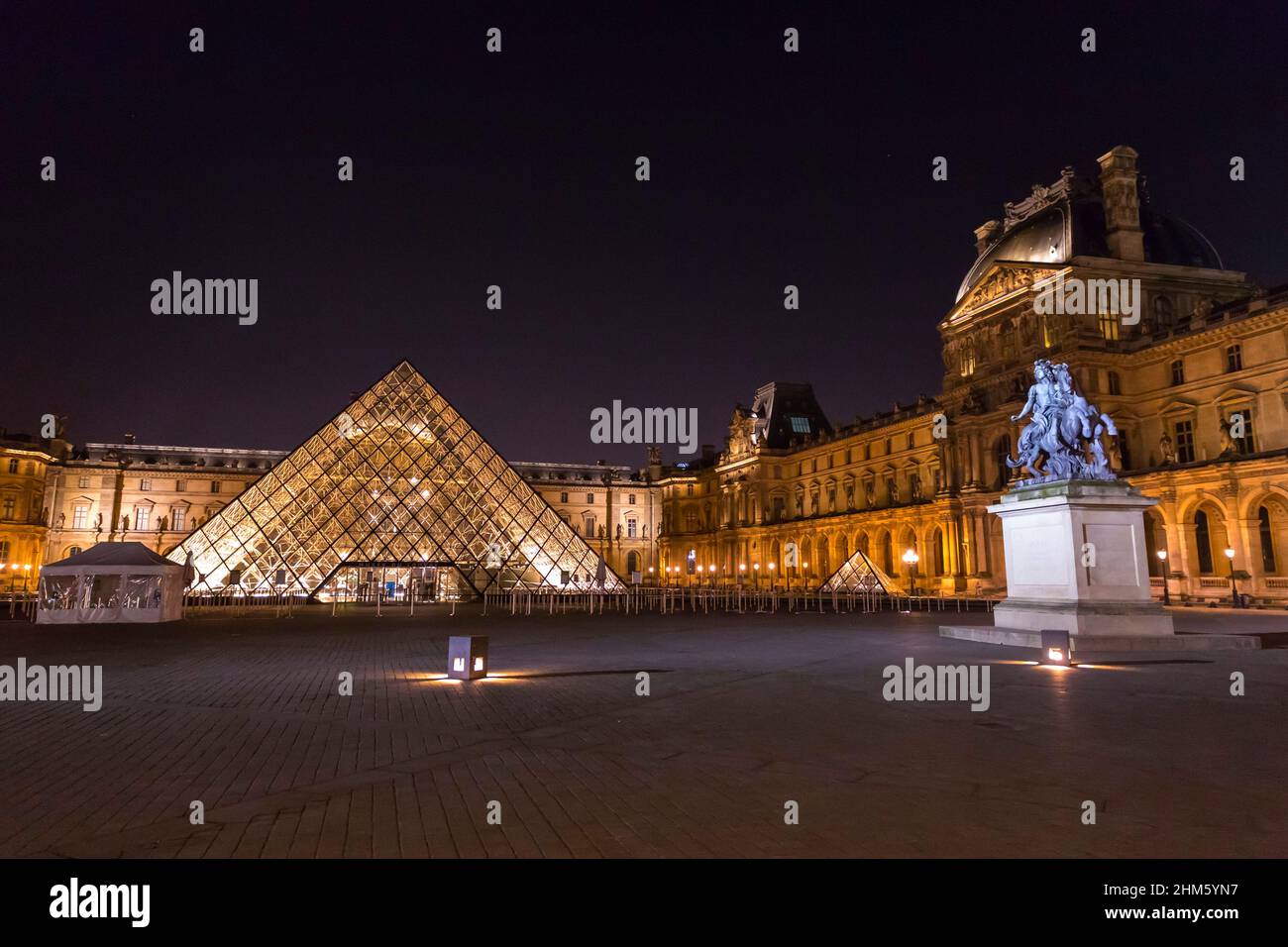 Paris, France - JAN 24, 2022: The glass pyramid of Louvre Museum, the main entrance to famous museum and gallery, completed in 1989. A beautiful winte Stock Photo