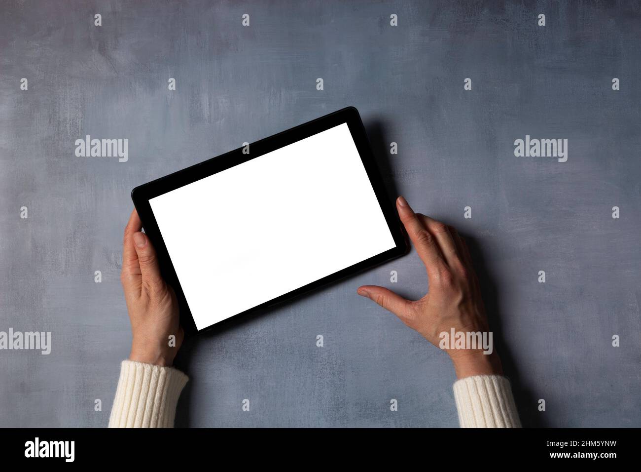 Woman hand holding digital tablet computer with blank white screen mock ...