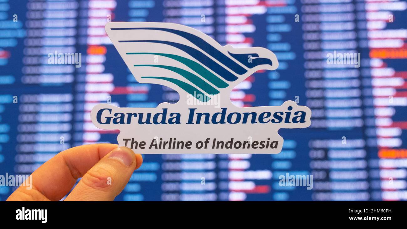 December 11, 2021, Tangerang, Indonesia. The emblem of the Garuda Indonesia airline against the background of an electronic board with the flight sche Stock Photo