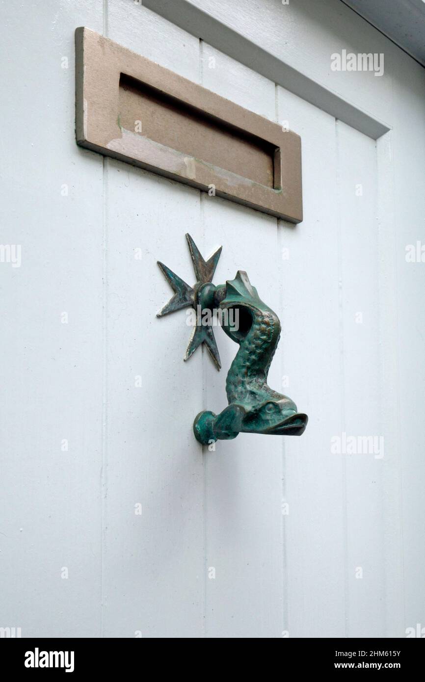 Old fish design used as a door knocker. Cast metal. Stock Photo