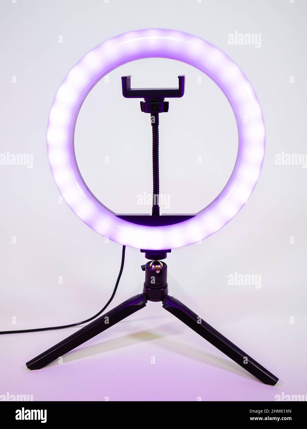 Ring lamp on a small tripod. Purple light. Stock Photo