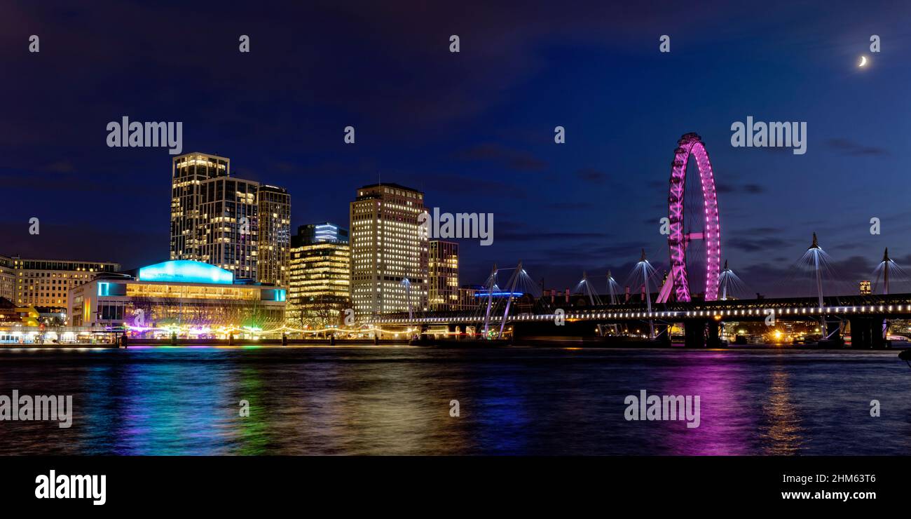 The London Eye and Southbank Centre across the River Thames in London at night close to Christmas Stock Photo