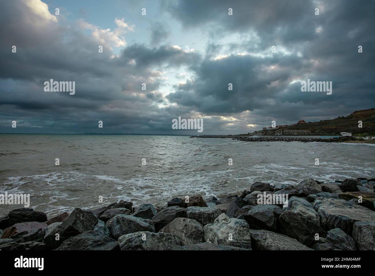 dramatic sky over the black sea with waves, clouds and stones Stock ...