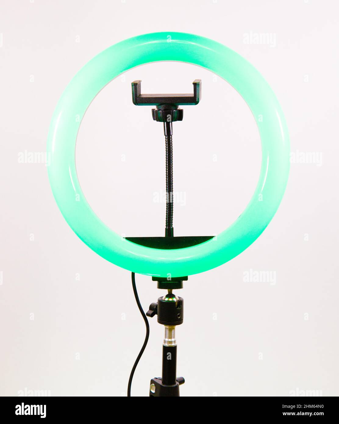 Round lamp with a smartphone holder. Green light. Stock Photo