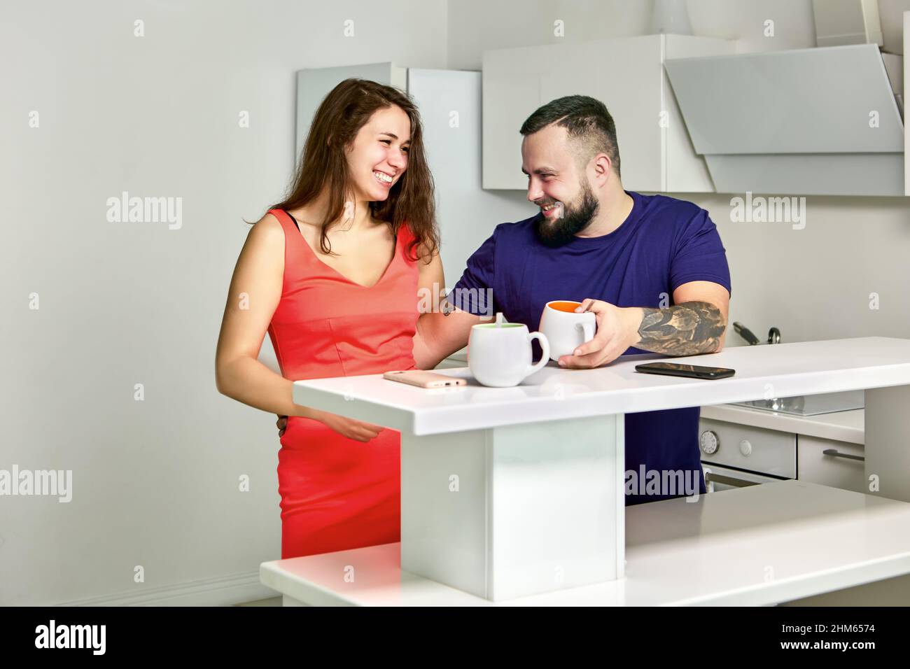 Flirl in office kitchen between cheerful employees. Stock Photo