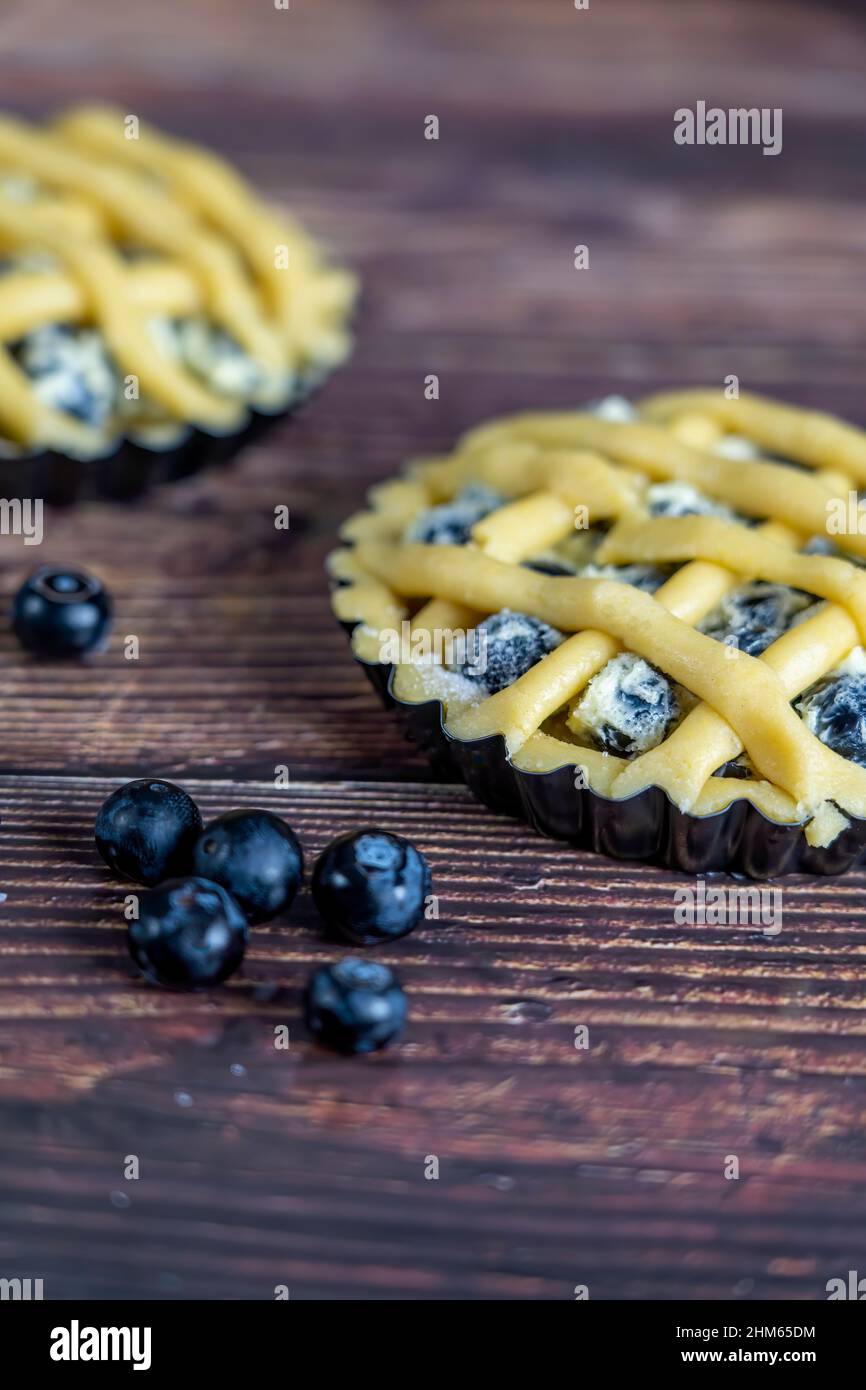 Small cups of delicious blue berry tart or pie  on wood table background. Stock Photo