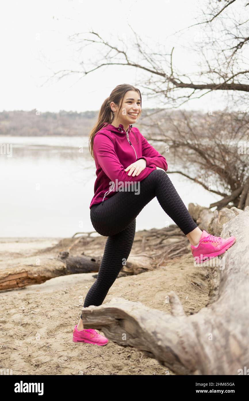 Smiling young woman stretching her legs and getting ready for the day Stock Photo