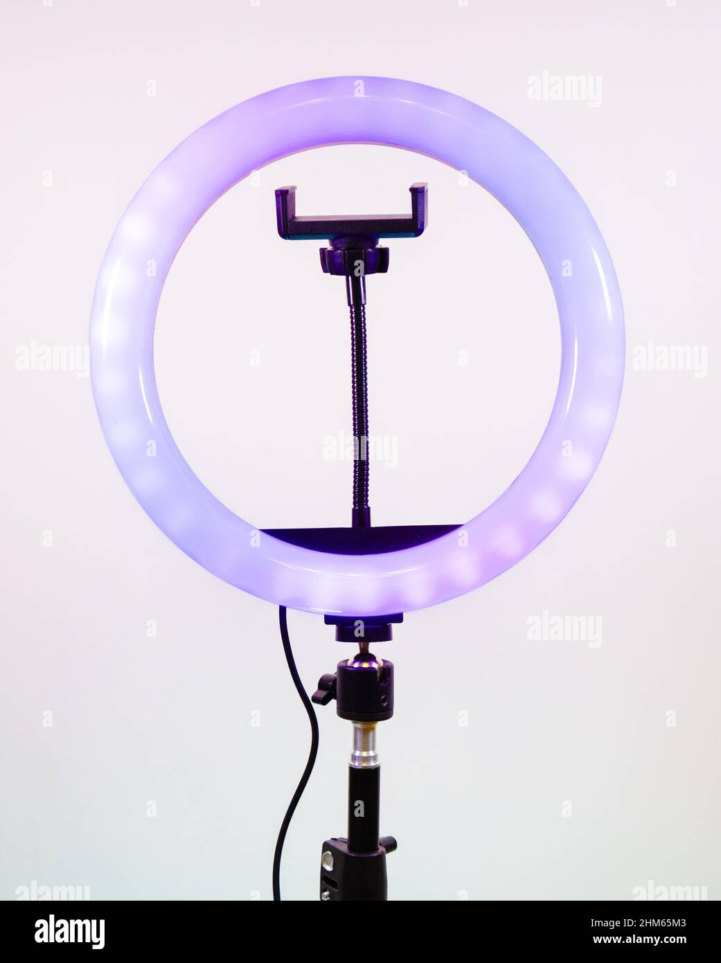 Ring lamp with phone holder. Purple light. Stock Photo
