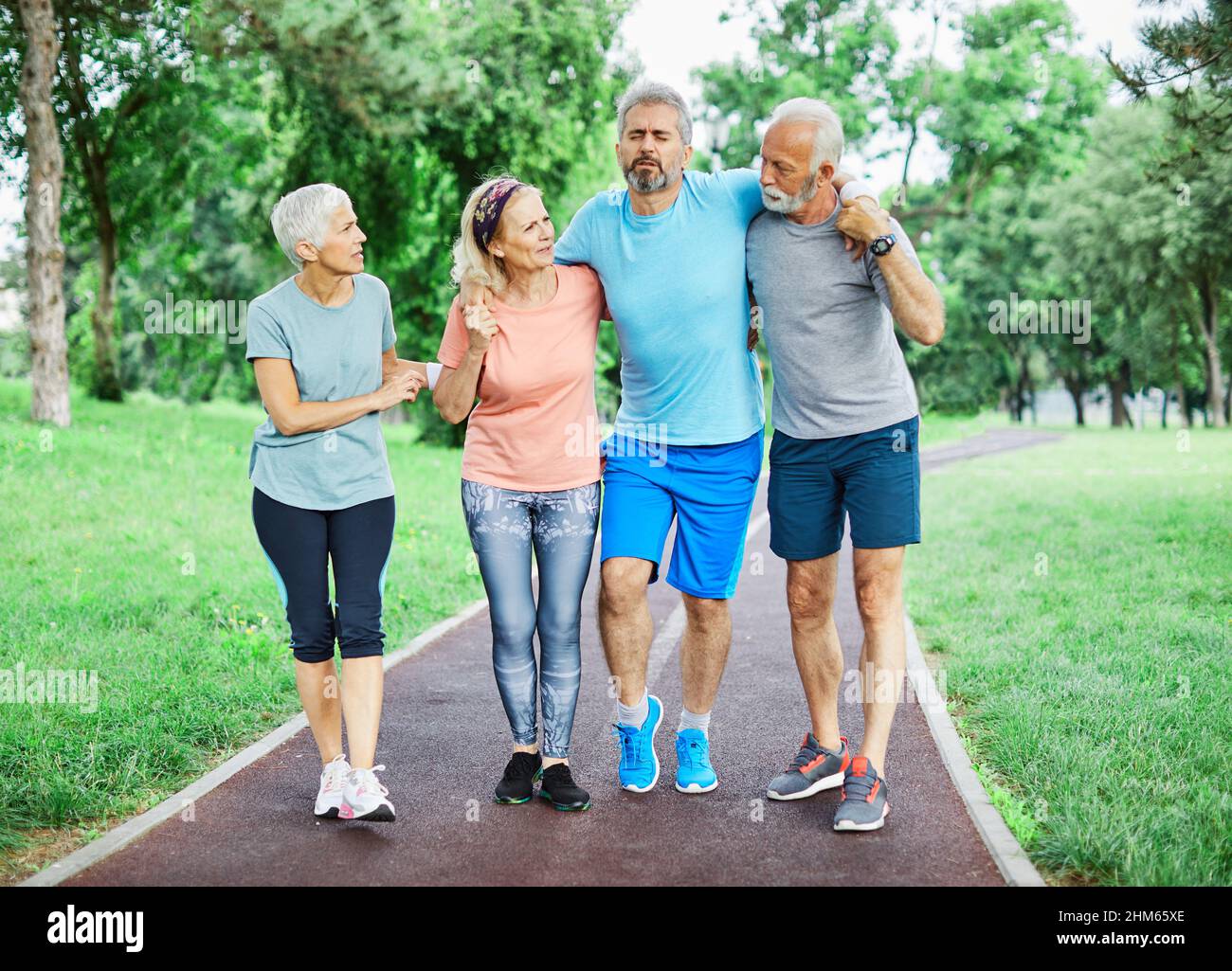 outdoor senior fitness woman man lifestyle active sport exercise injury pain ache leg knee ancle Stock Photo