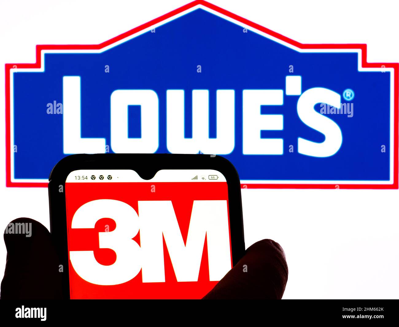 In this photo illustration, the 3M logo is displayed on a smartphone screen with a Lowe's Companies, Inc. logo in the background. Stock Photo