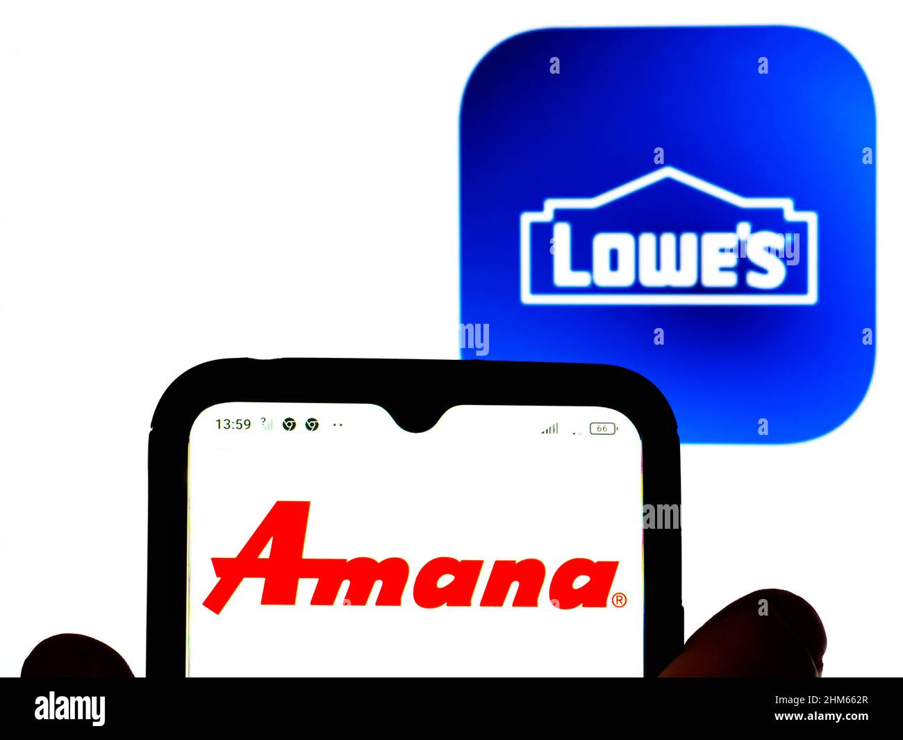In this photo illustration, the Amana® Appliances logo is displayed on a smartphone screen with a Lowe's Companies, Inc. logo in the background. Stock Photo