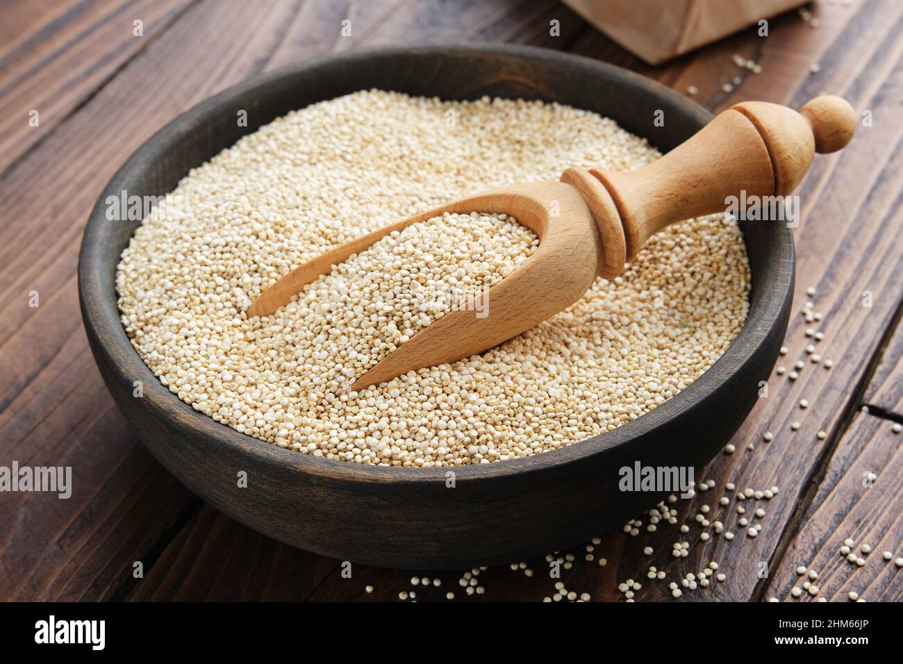 Quinoa grains in a wooden bowl on a wooden table. Stock Photo