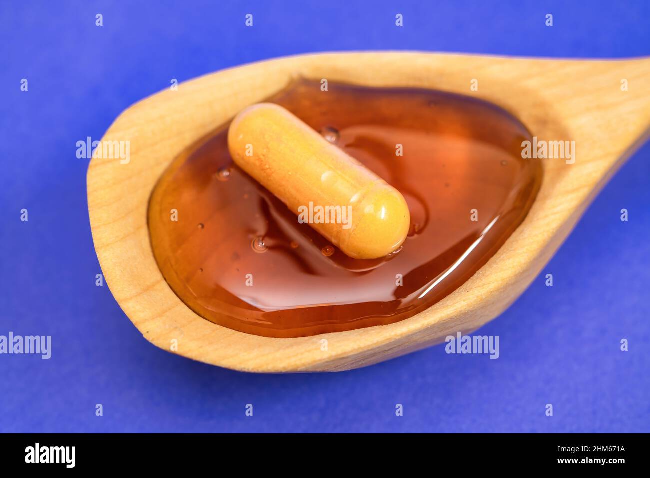 Concept of natural medicine, a pill is seen over honey Stock Photo