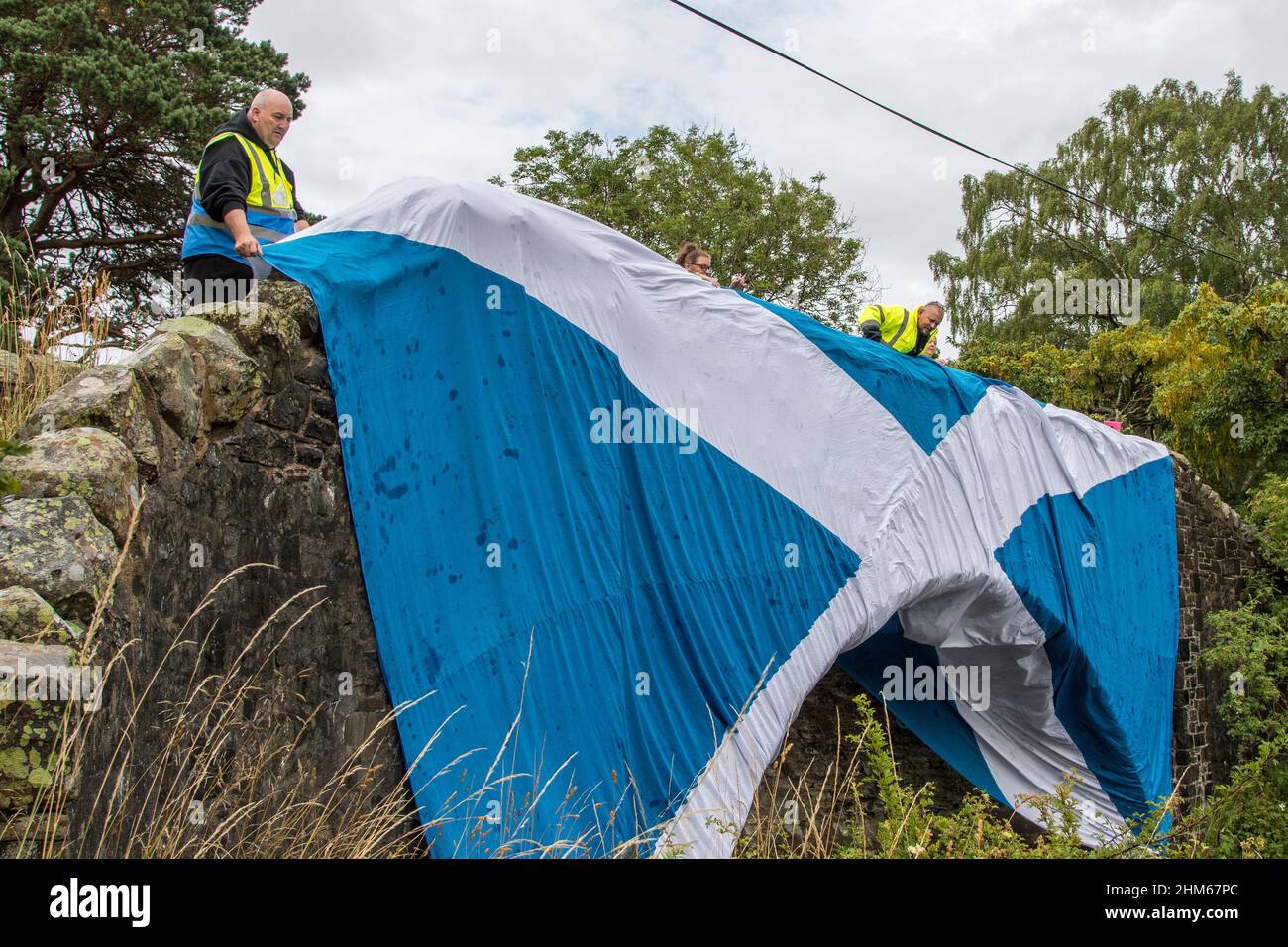 Scottish Freedom Convoy supporters raising saltire over bridge at St Marys Loch, Scottish Borders Stock Photo