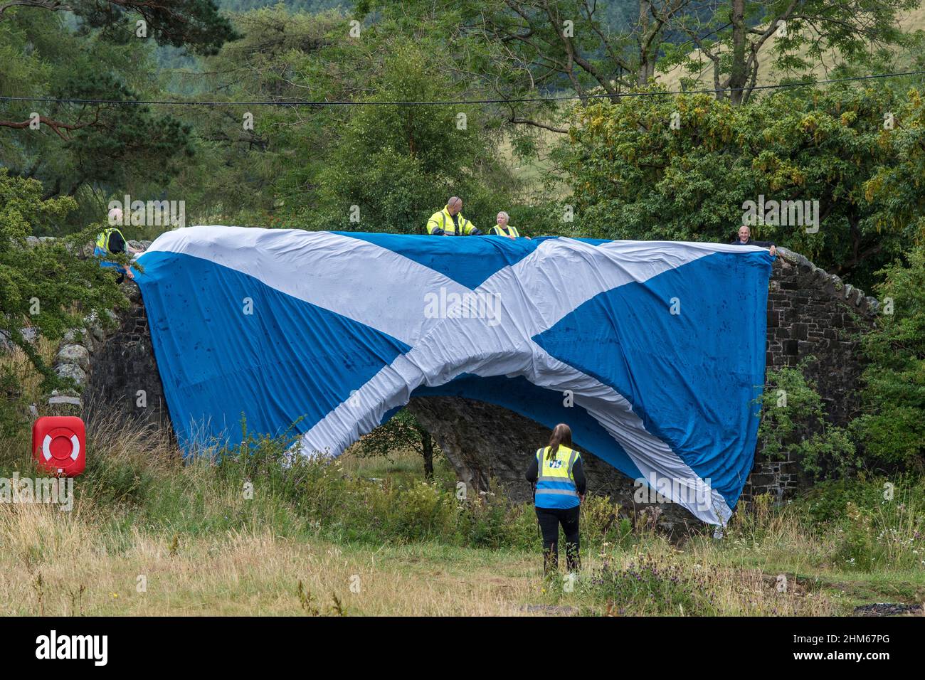 Scottish Freedom Convoy supporters raising saltire over bridge at St Marys Loch, Scottish Borders Stock Photo
