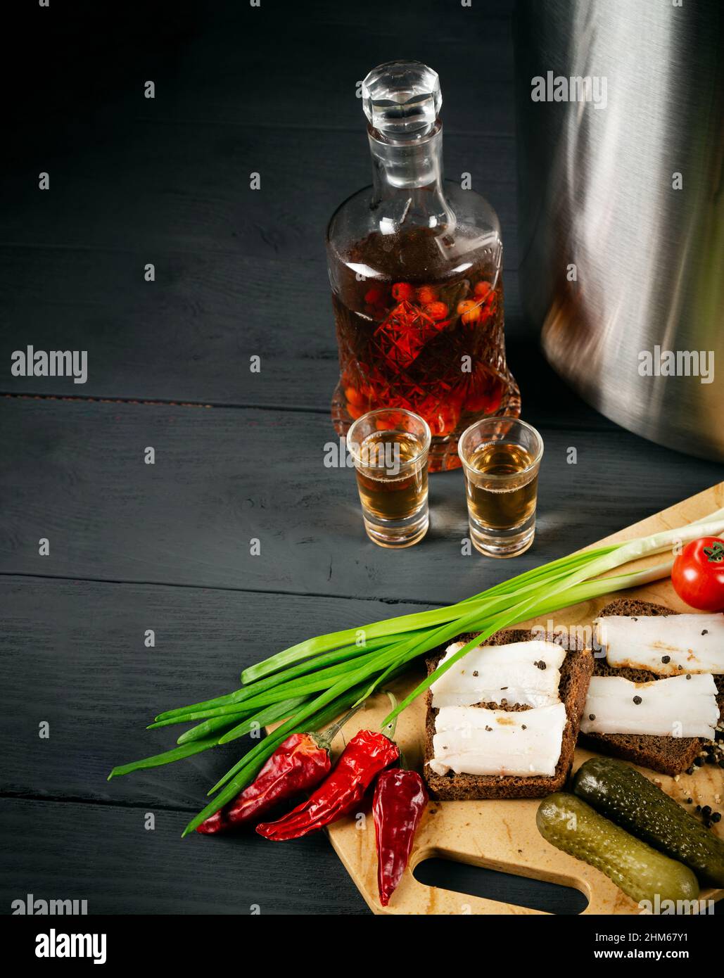 Alcoholic drink with an appetizing snack on a black wooden background. With copy space. Stock Photo