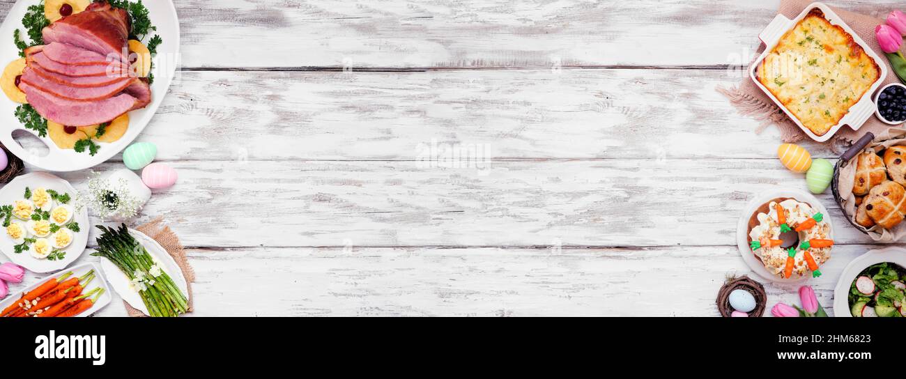 Classic Easter ham dinner. Top view double border on a white wood