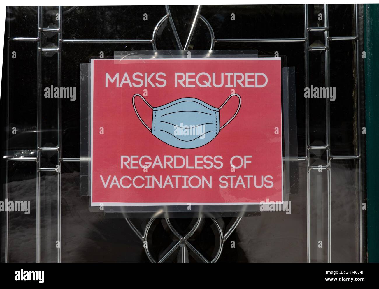 A Masks Required sign indicating regardless of vaccination status on an office door at the Town of Lake Pleasant, NY USA Stock Photo