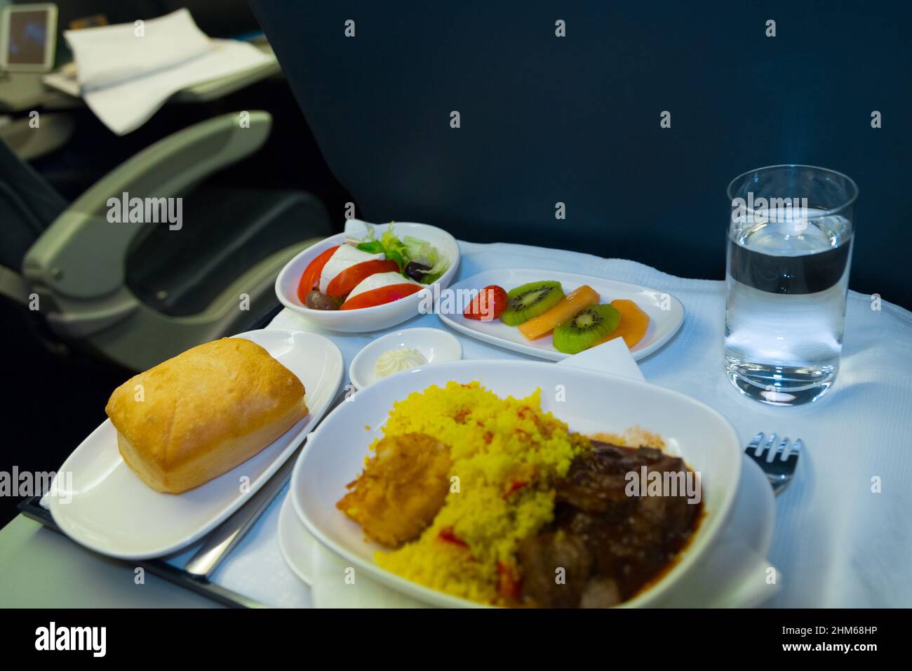 Food served on board of business class airplane on the table. Tray of food in the airplane. Tray of food on the plane, business class travel. Prepared food on the plane Stock Photo