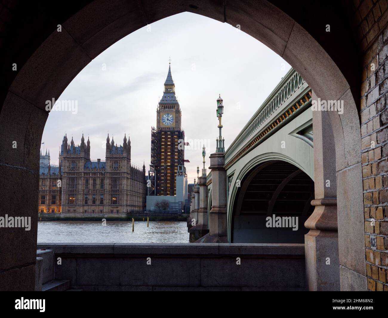 Houses of Parliament and Westminster Bridge seen from an archway on the south bank of the River Thames, London. Stock Photo