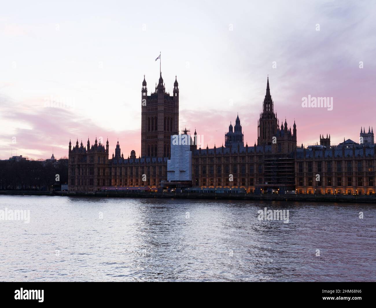 Houses of Parliament with Victoria Tower on a winters sunset seen from the north bank of the River Thames, London. Stock Photo