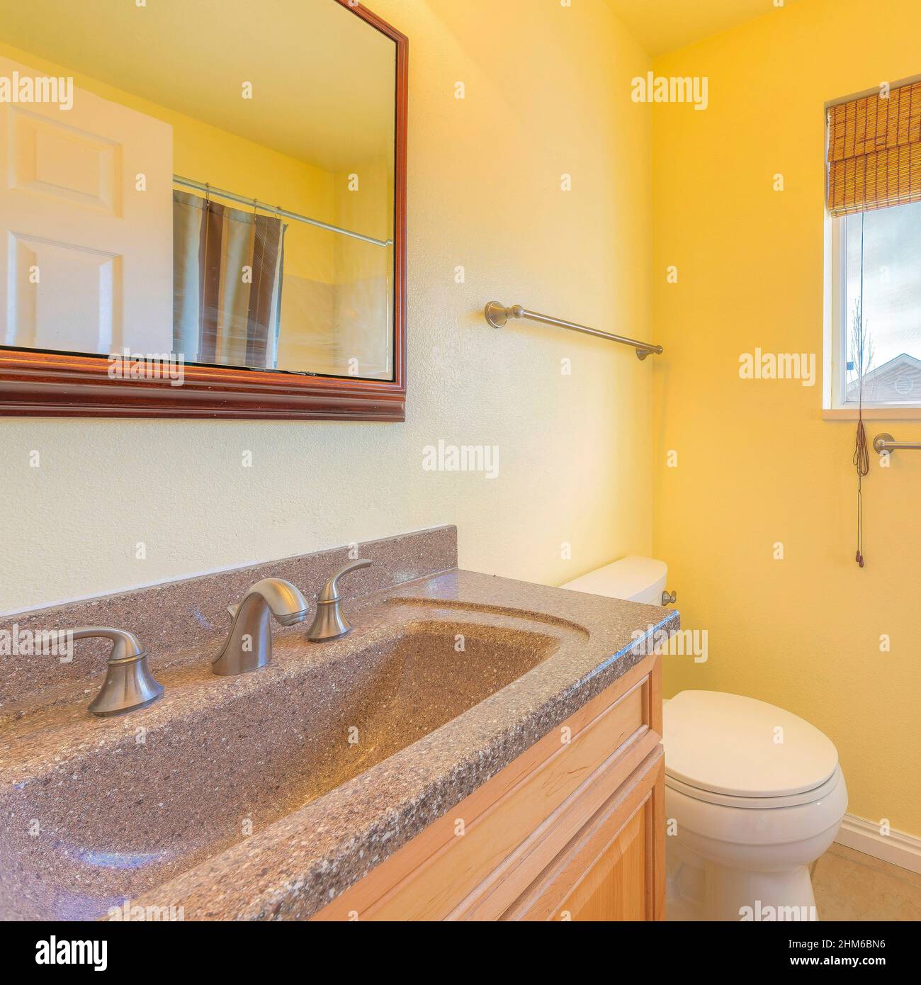 Square Small yellow bathroom interior with bamboo curtain on the window Stock Photo